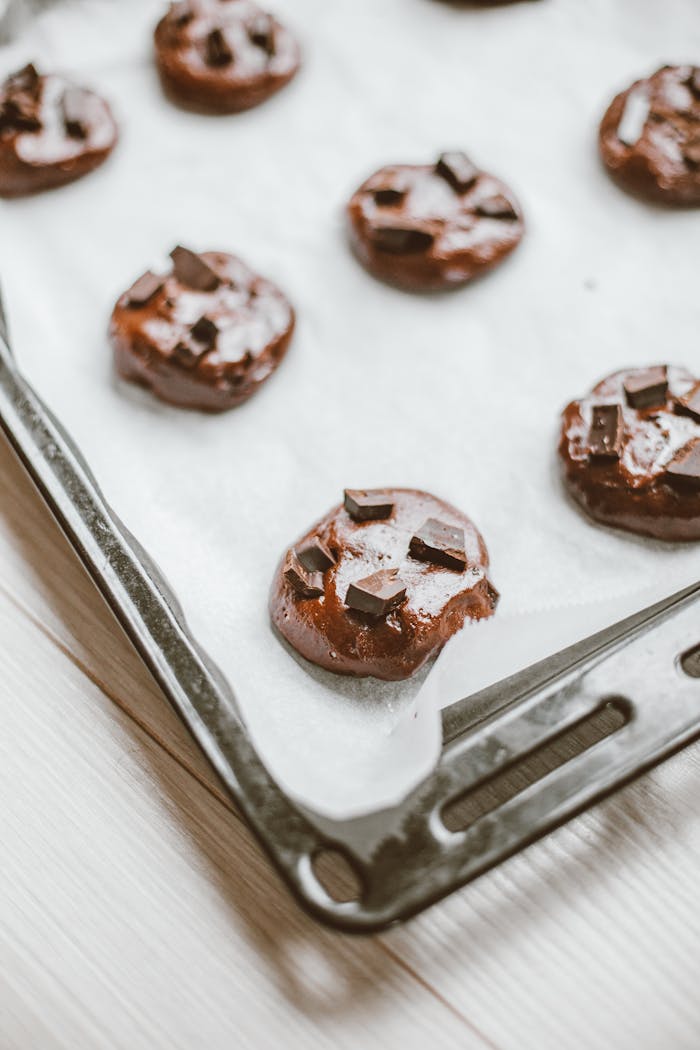 Close-up of chocolate chip cookie dough on parchment paper ready to bake.
